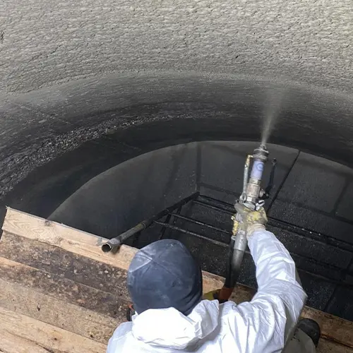 ERGELIT-KS2 wird im Nassspritzverfahren auf die Wand eines Abwasserbehälters gespritzt