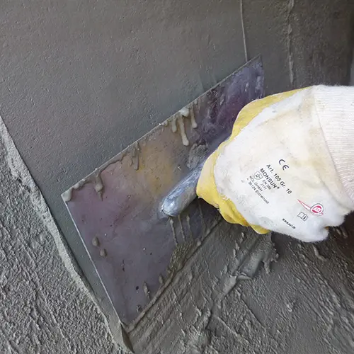 ERGELIT-KT10 wird mit der Kelle an der Wand geglättet