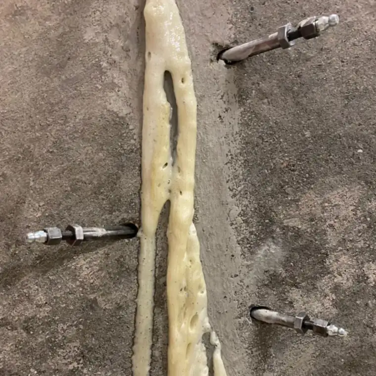 Injiziertes Hermes-Flexseal PUR tritt zwischen Stahlpackern aus einem Riss in der Betonwand aus