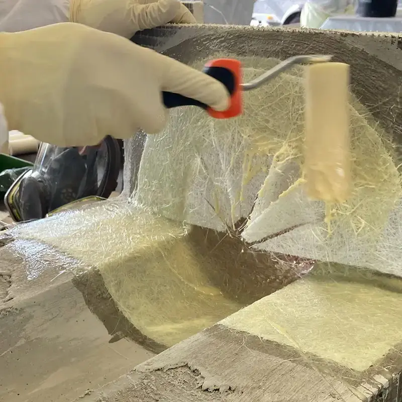 Glasfaserlaminat wird im Kurs mit der Rolle verdichtet